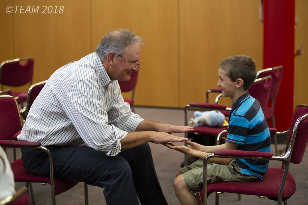 Jeff Ingram sits and plays a game with a child