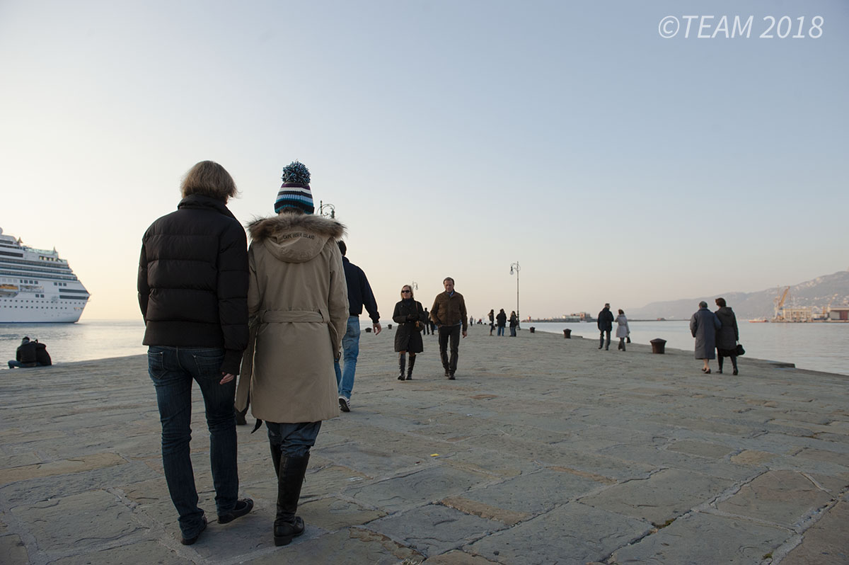 Two Italian women walk along the waterline.