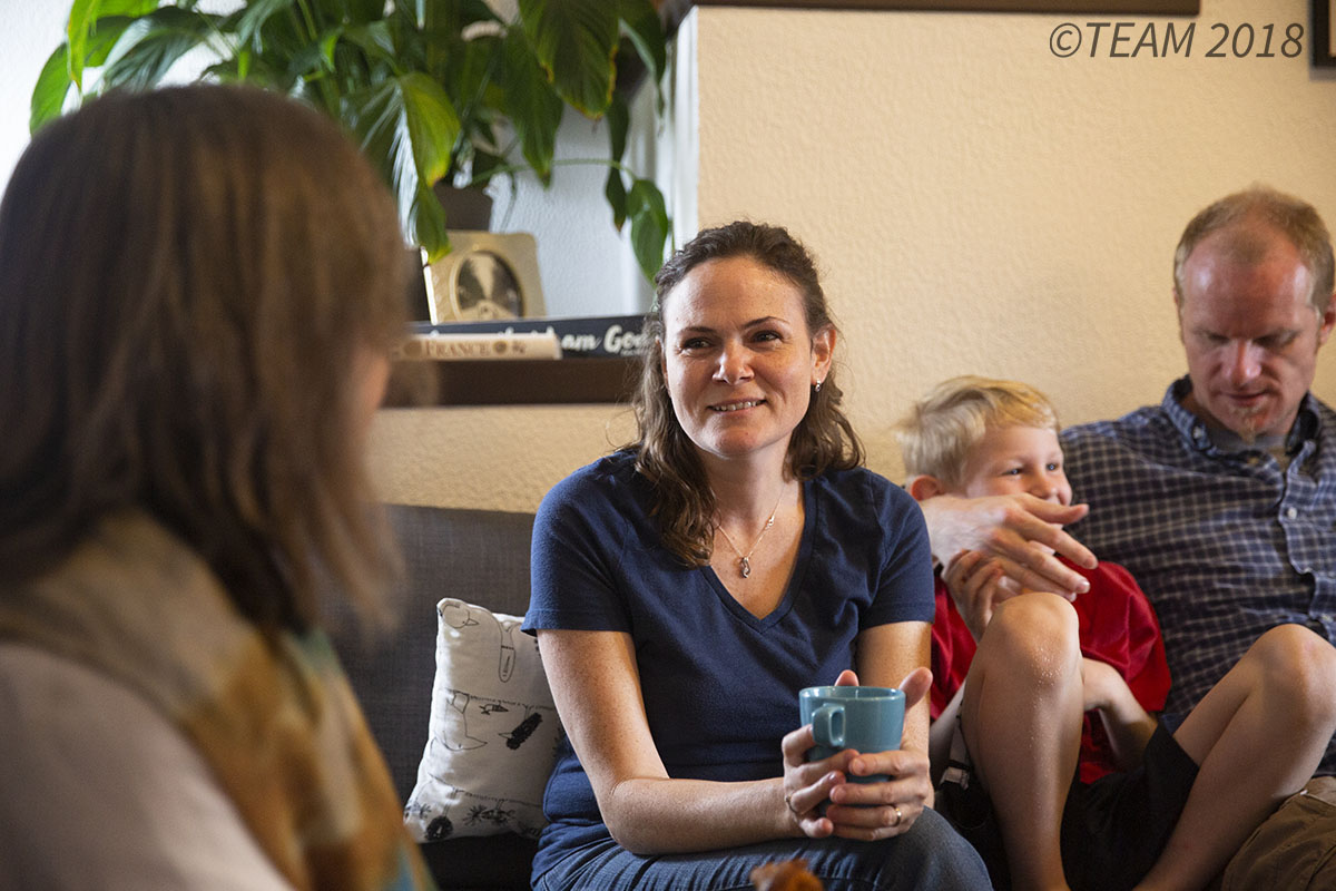 Two women sit and talk.