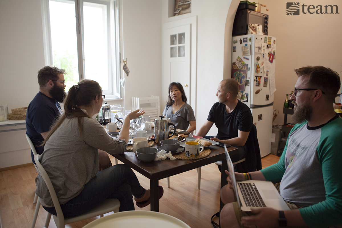 A group of people sit together over a meal to discuss their missions strategy