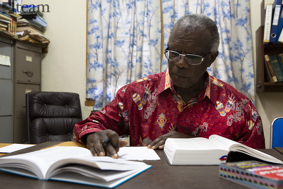 Simson led the Bible translation team for the Hatam Bible. Here he sits at his desk.