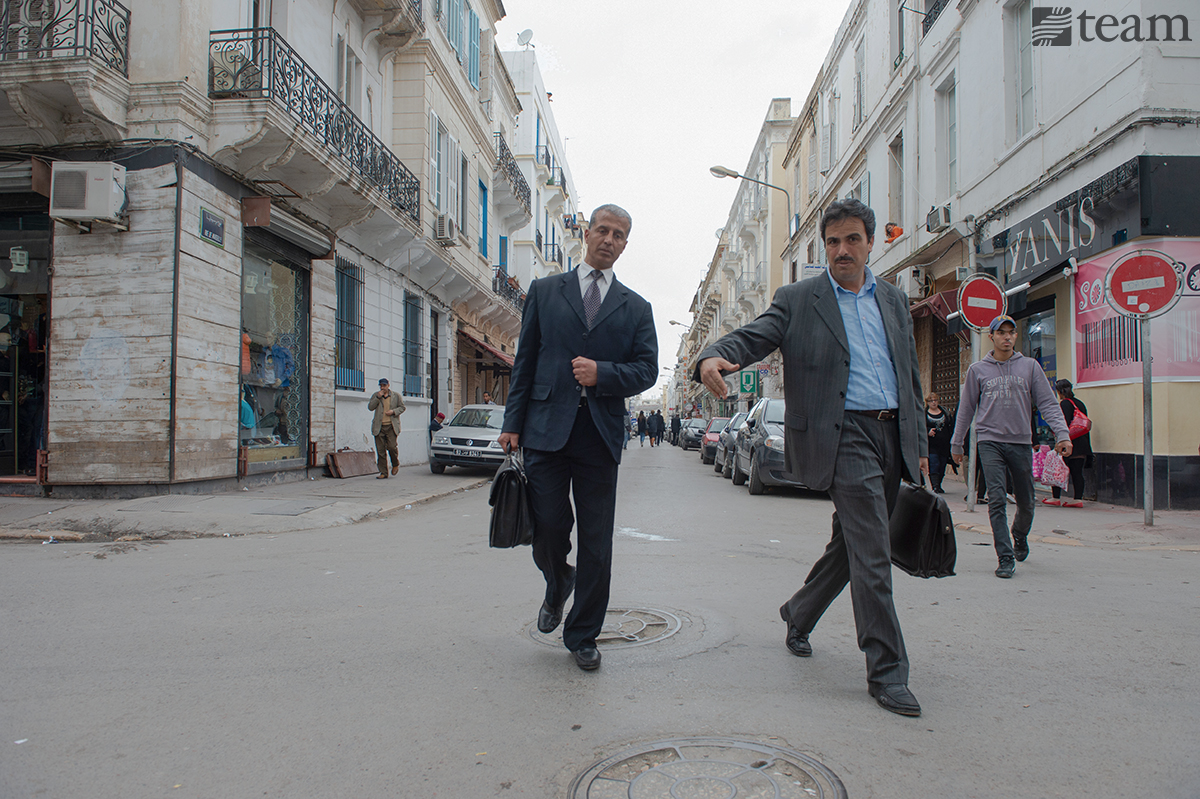 Men walking in business attire in the street