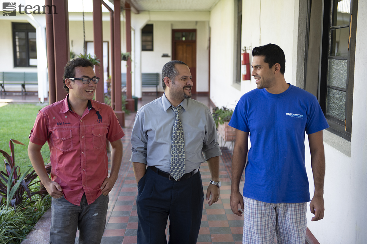 Three men walk and talk