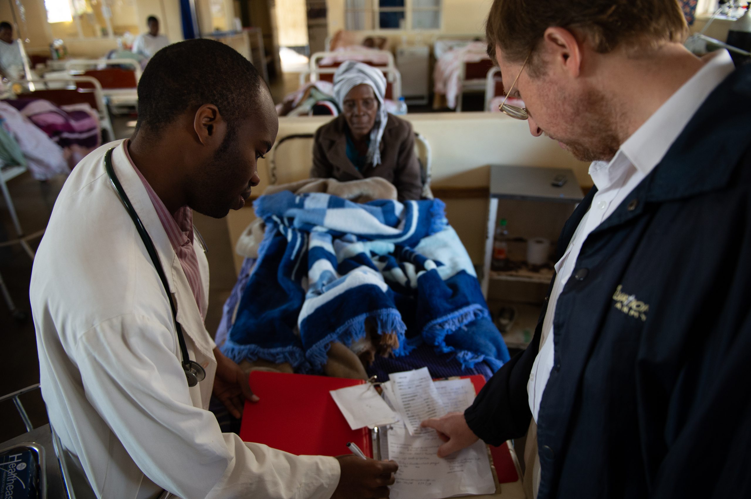 Two Karanda Mission Hospital doctors look at a patient's chart.