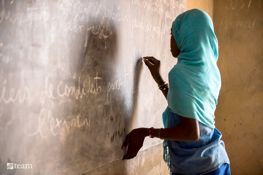 Girl writing on a chalkboard in Chad, Africa