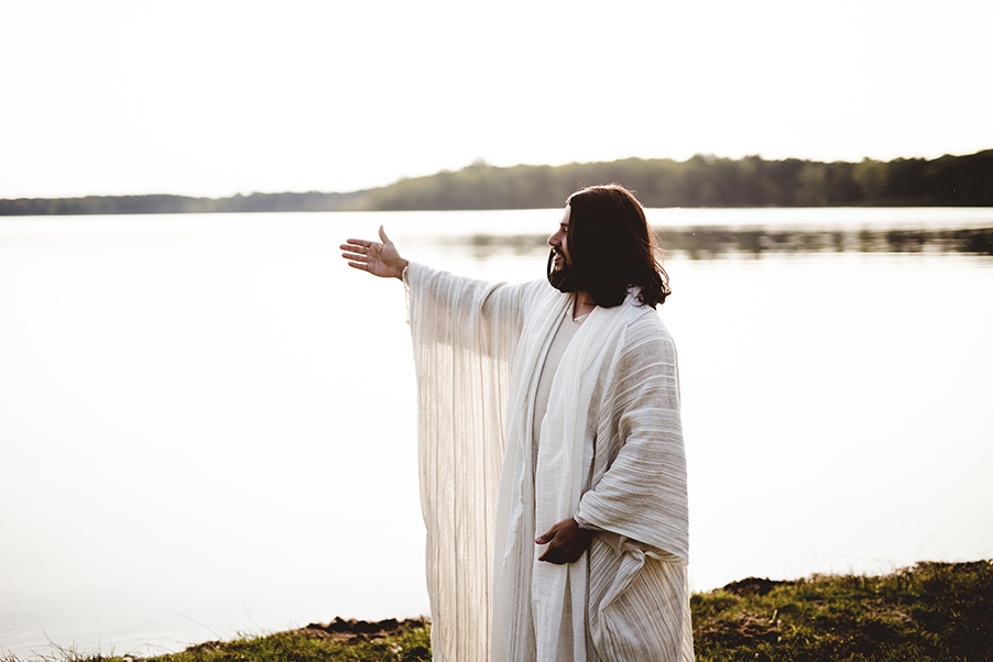 Jesus standing with outstretched hand over the water.