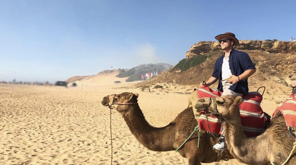 Man sitting on a camel in the desert.