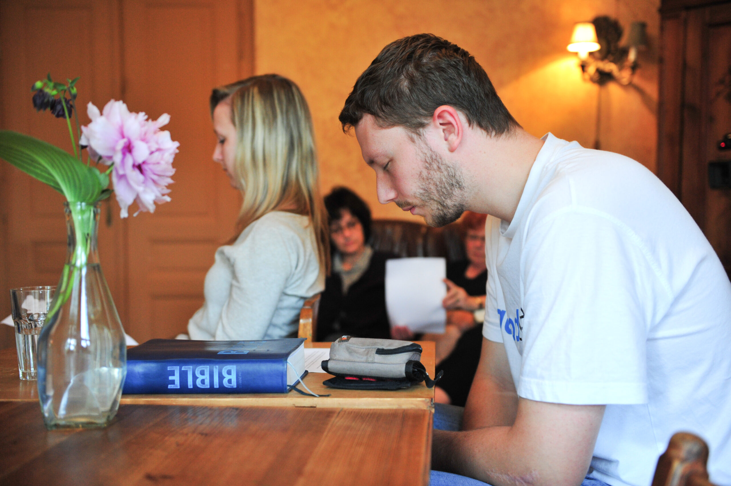 Man praying at table.