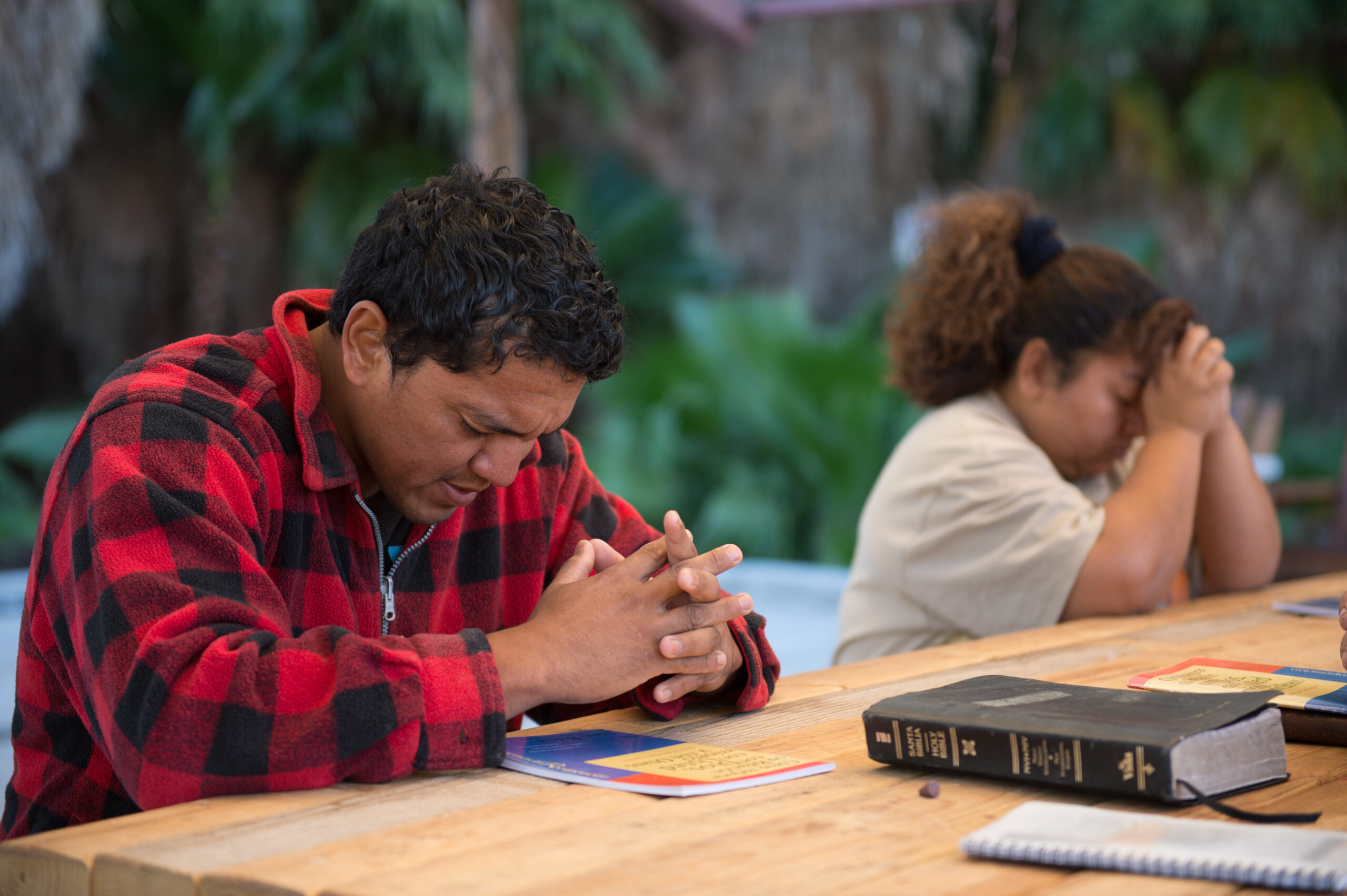 Man praying at a table.