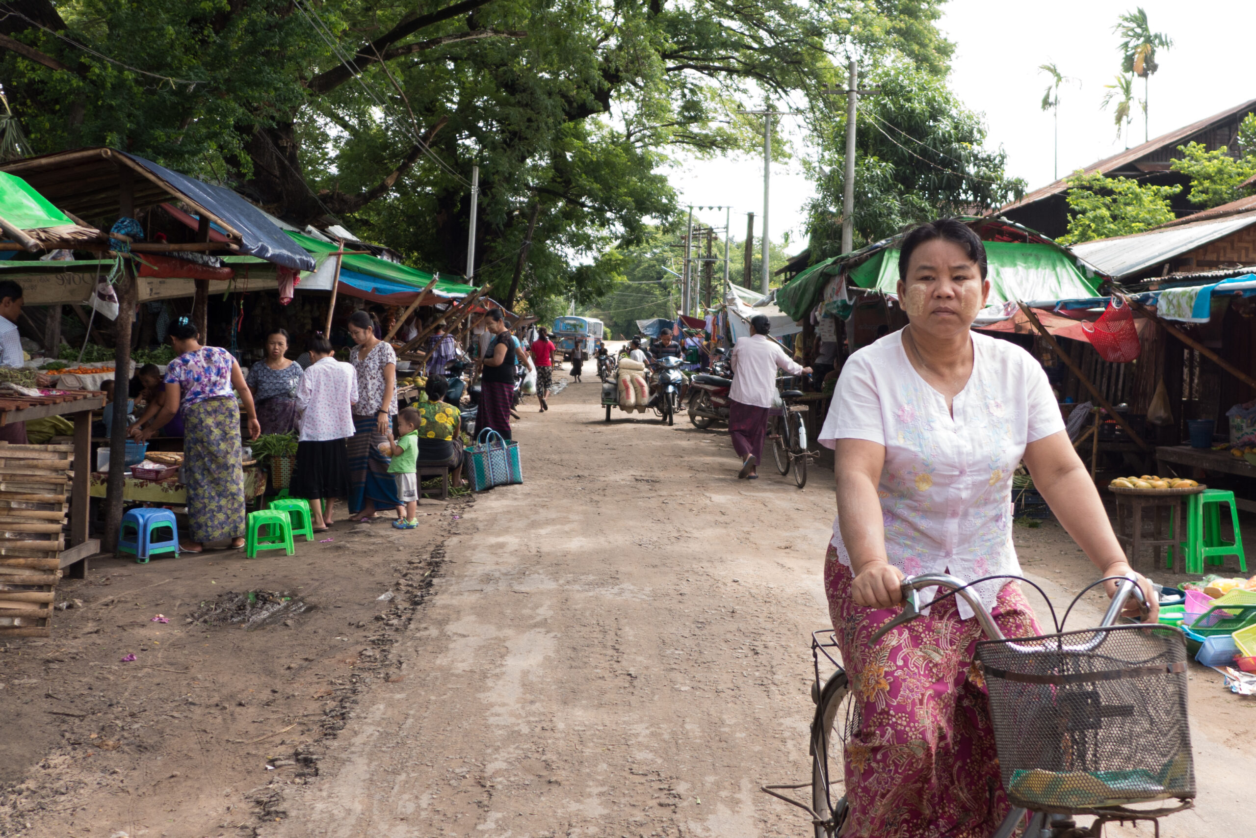 Woman riding a bike through the market.