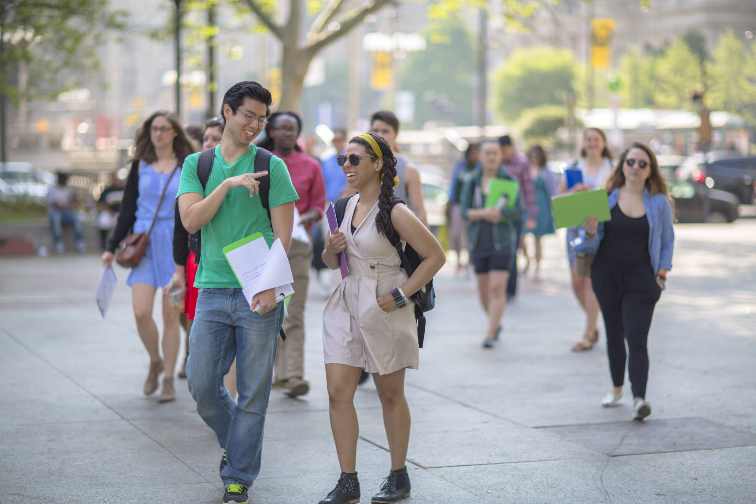 Group of people walking with folders.