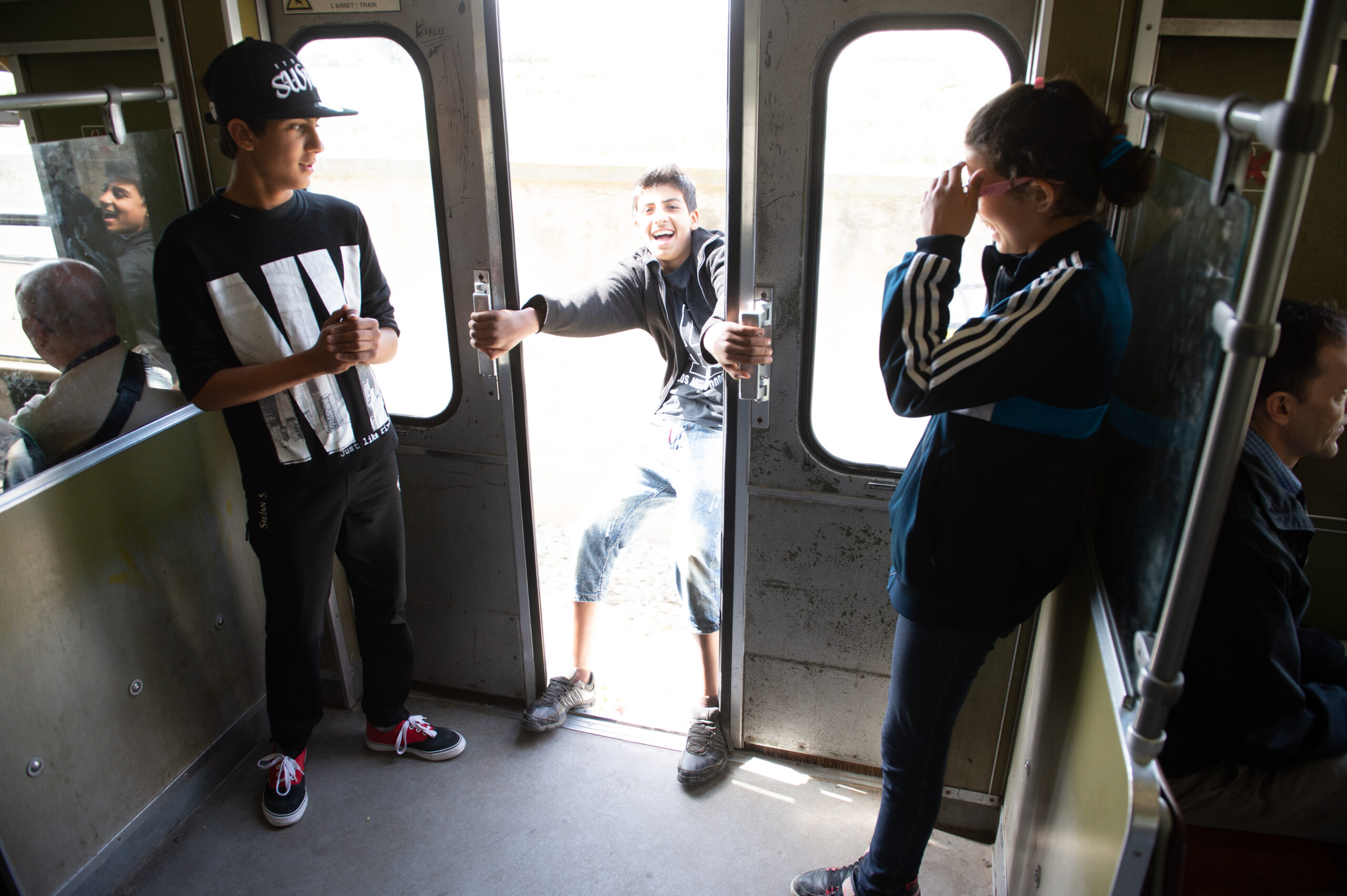 Three boys riding a train.