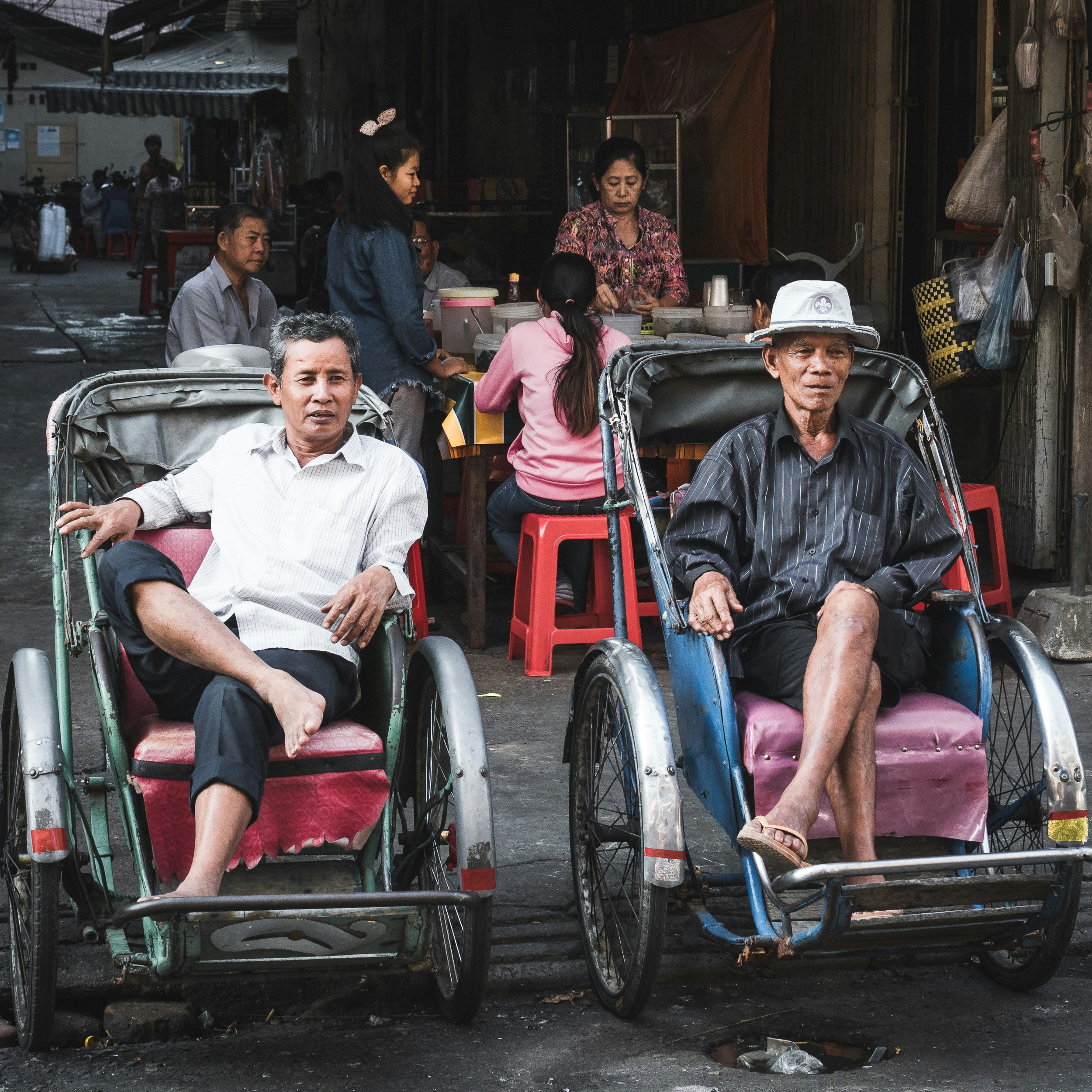 Two men sitting at the market.