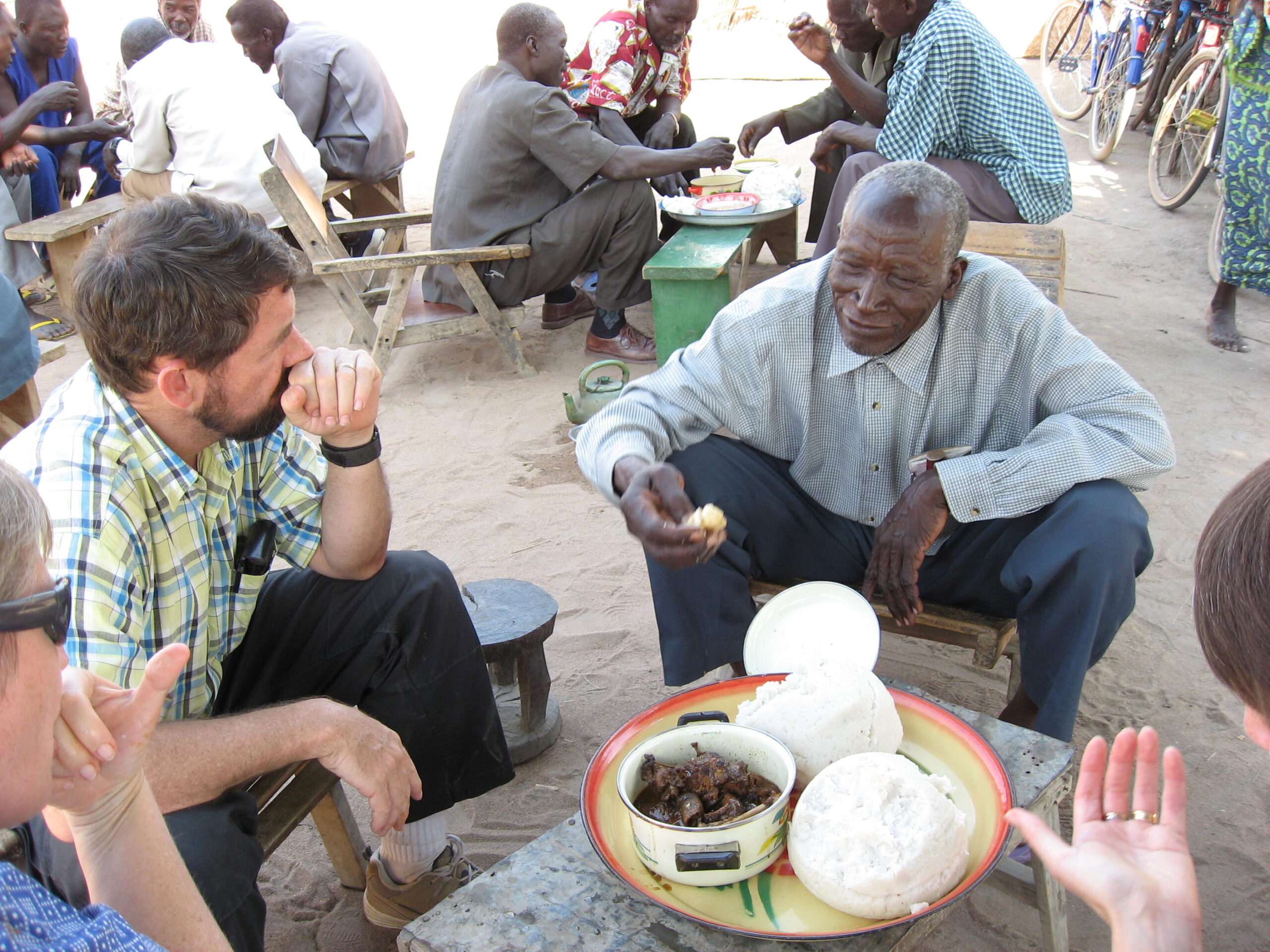 A group sitting and having a meal together in Africa.