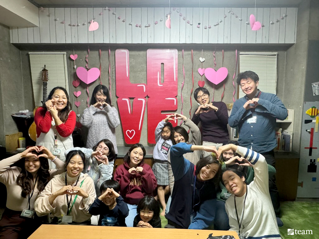 Group in Japan showing heart signs.