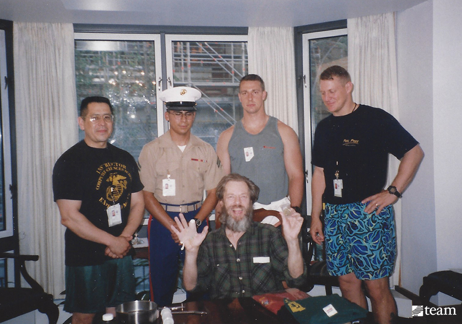 Man with a missing finger sitting at the table with men from the military.