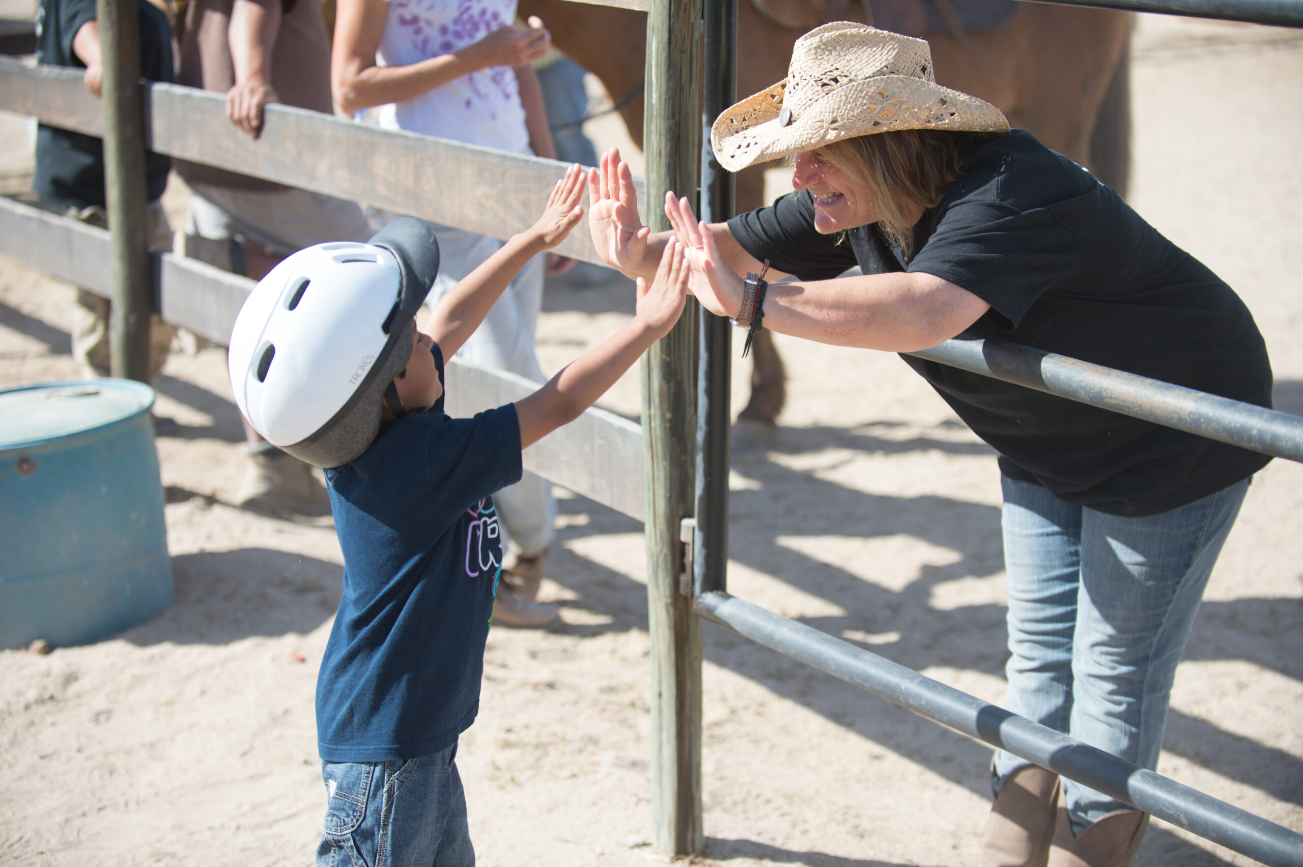 A lady give high fives to a small boy.