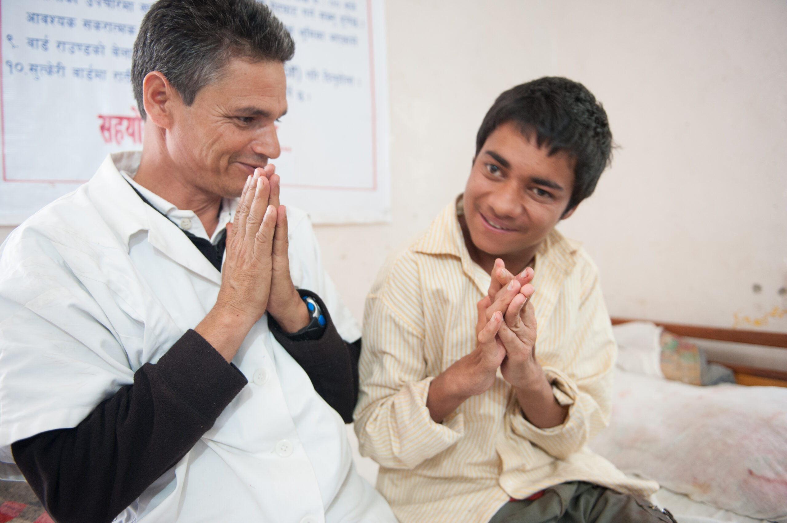 A doctor praying with a patient during his exam.