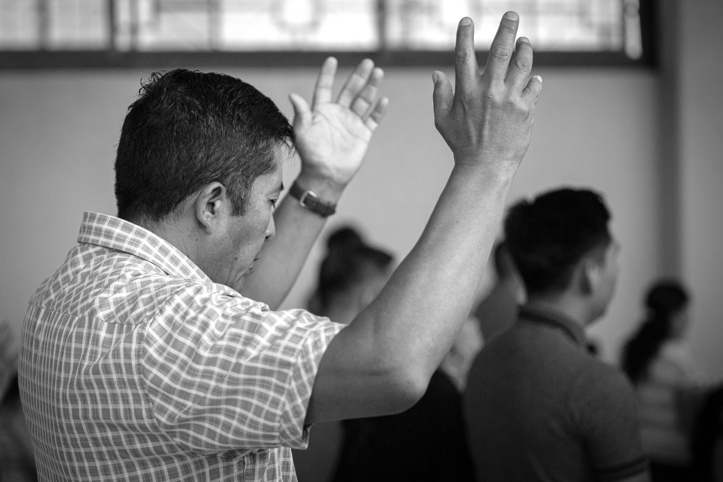 A man worships with his hands raised.