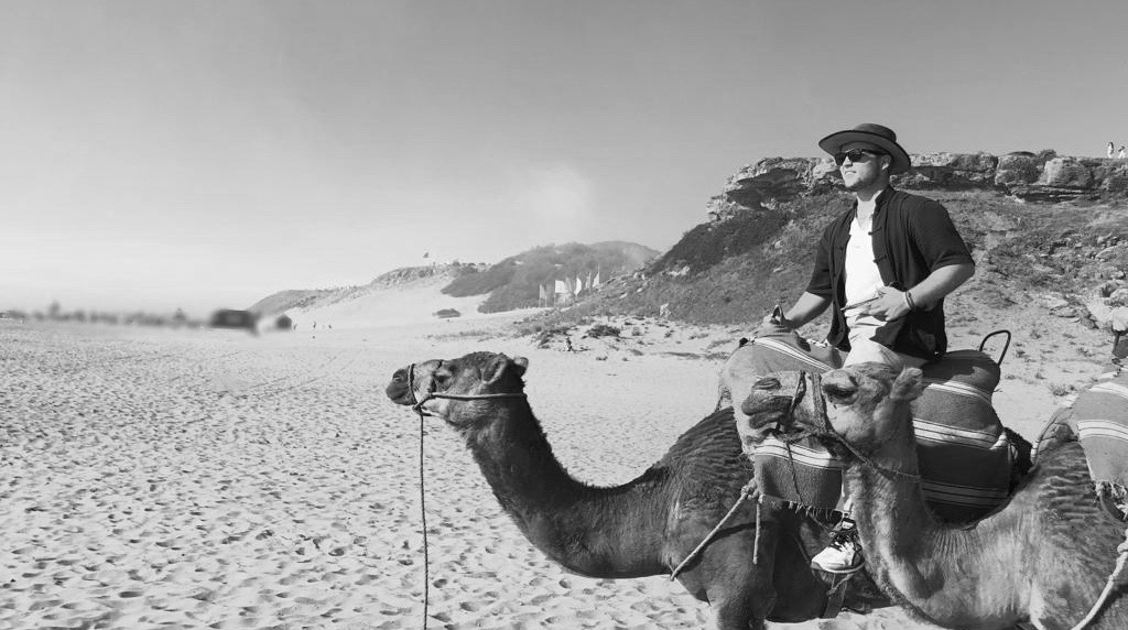 A man riding on a camel in the desert.