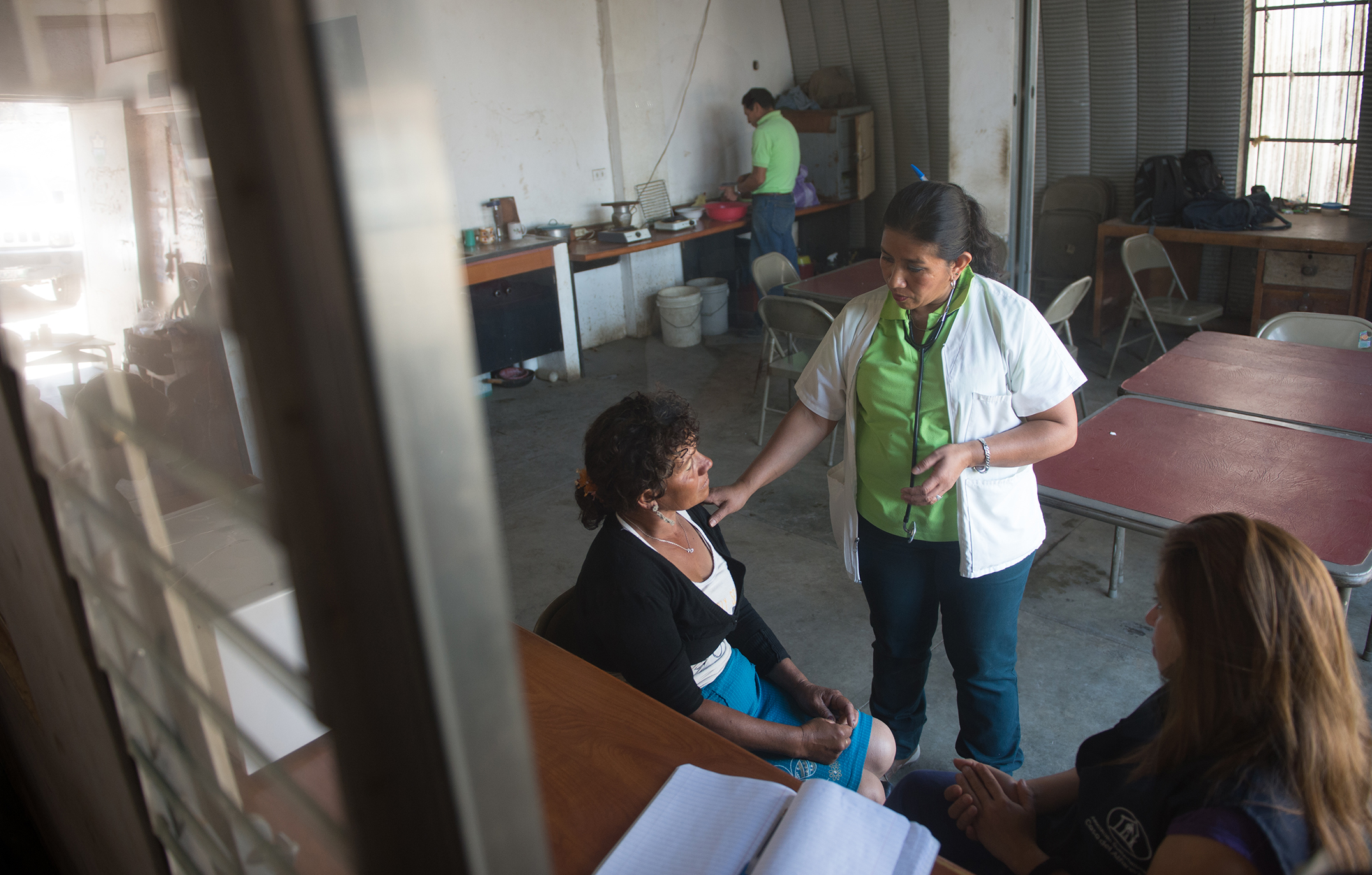 A doctor speaks to a patient in an open room.