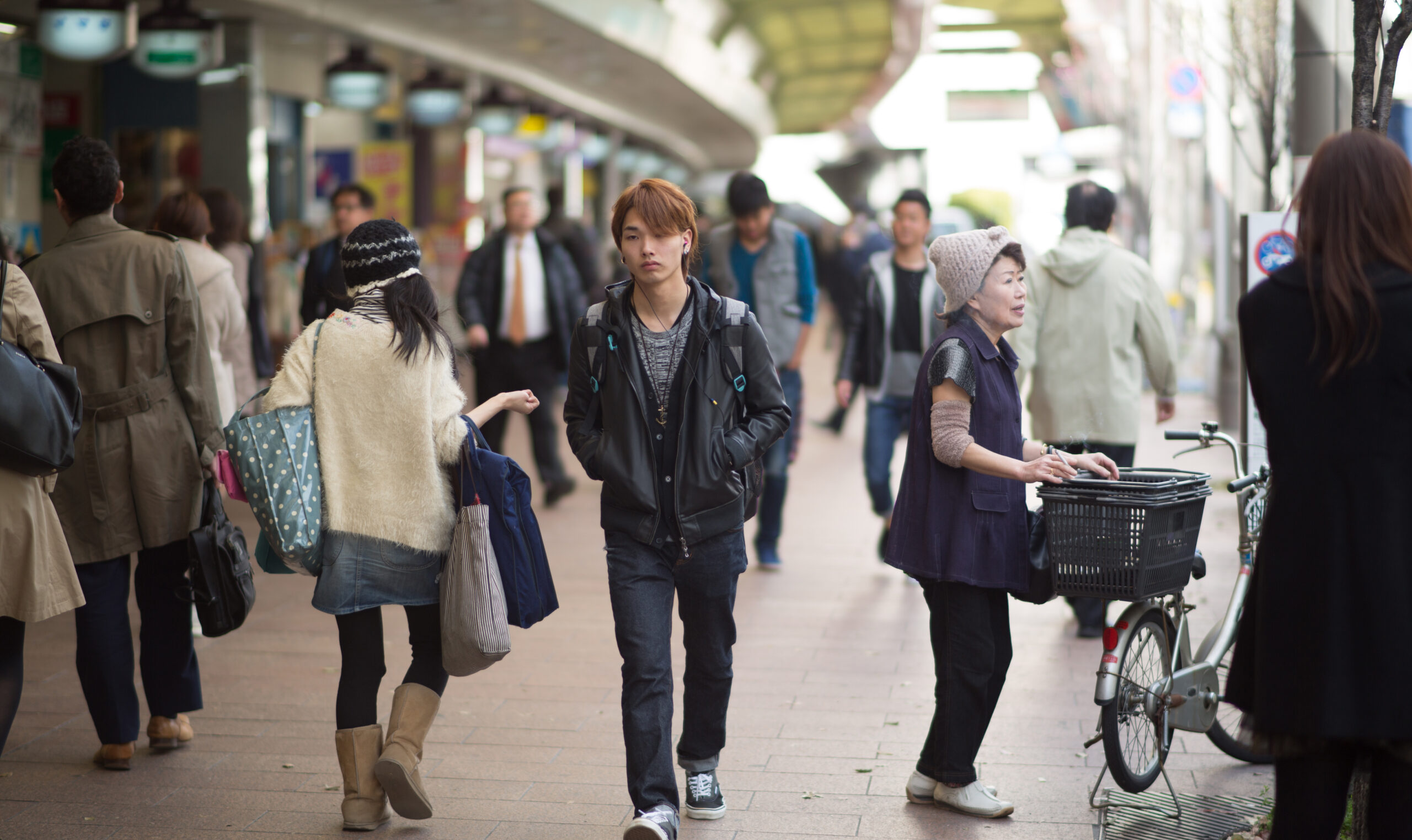 Japanese boy walks through a crowded street.