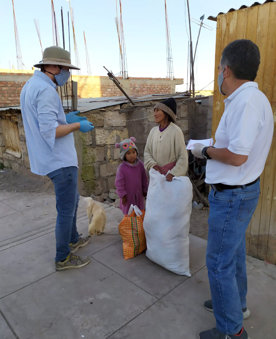 Two men deliver supplies to a mother and her daughter.