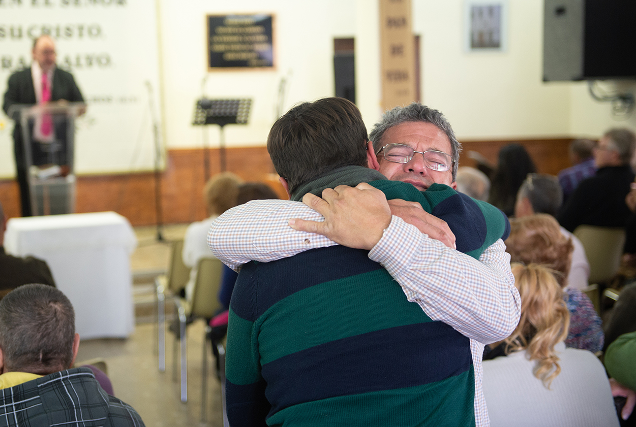 Two men hug in a church service.