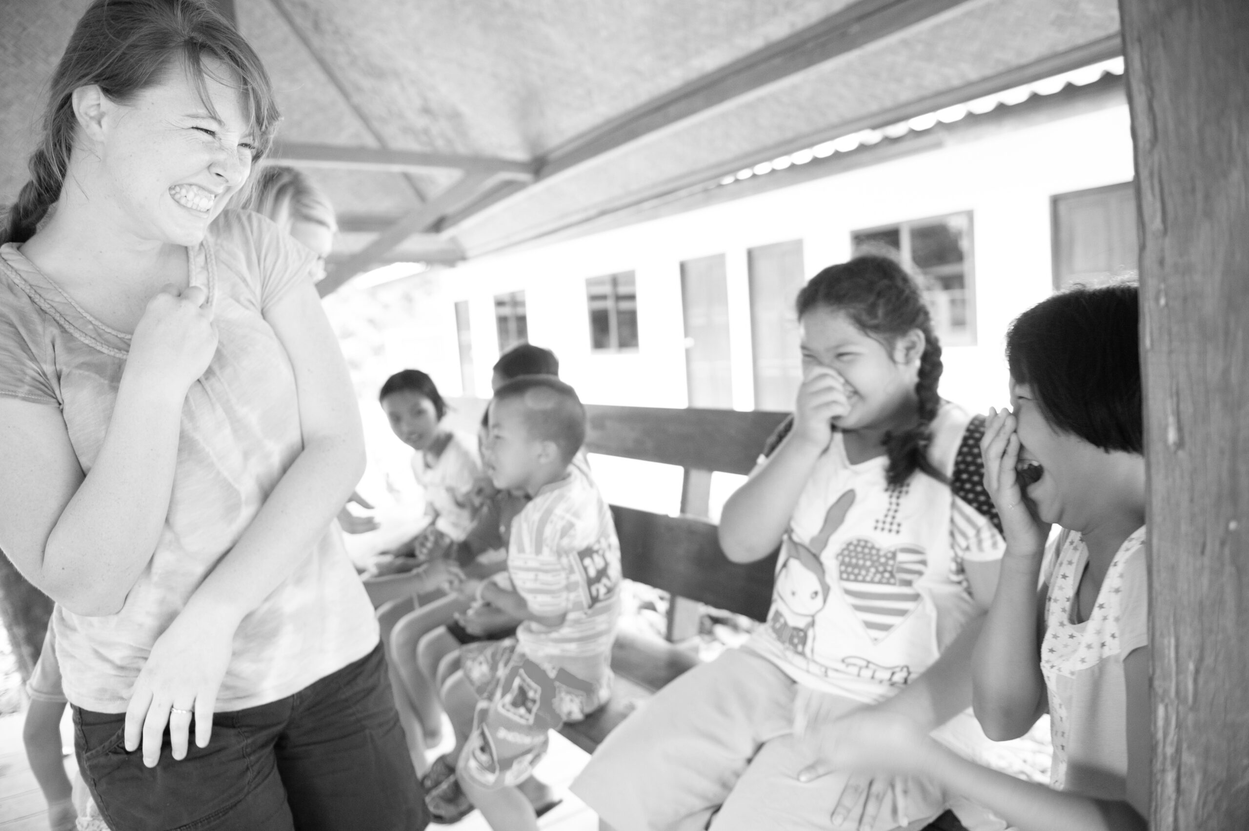 A girl laughs with a group of young girls.