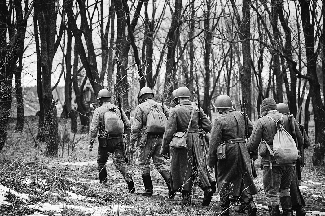 World War II men walking in a field.