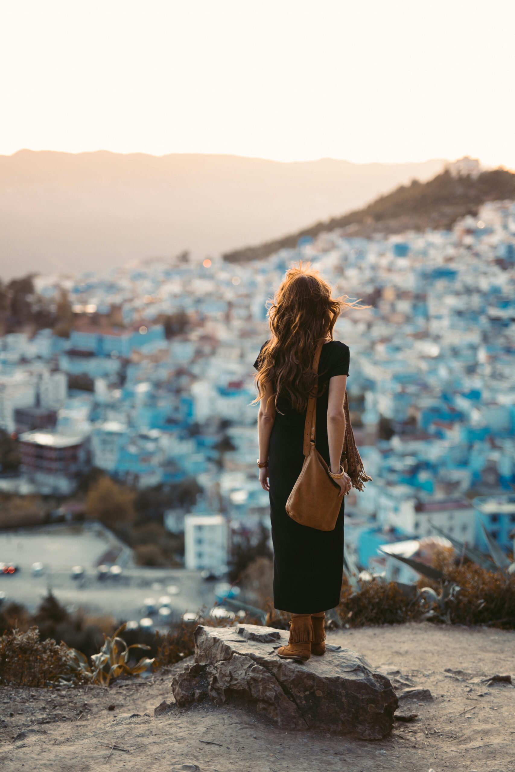 A woman stands overlooking a city.