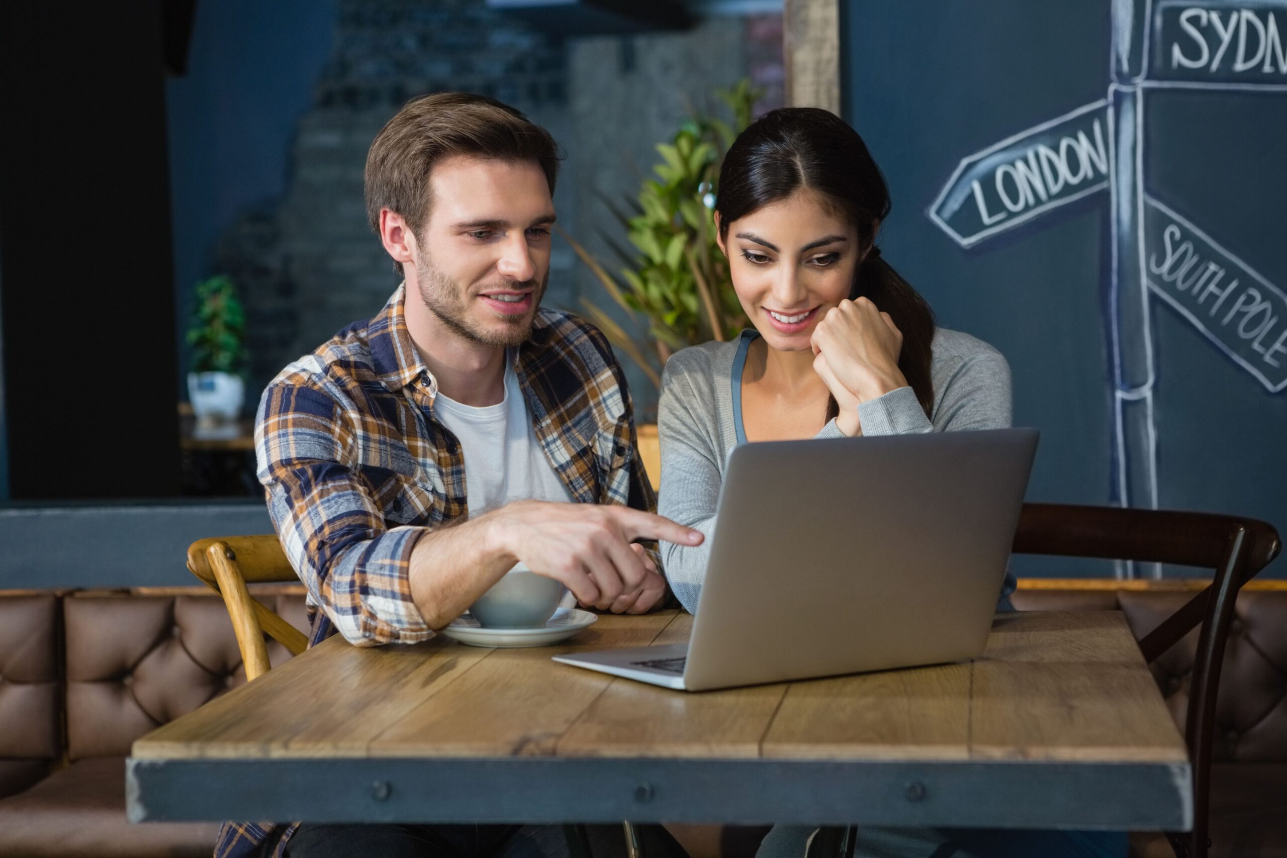 A man and woman look at a computer and talk.