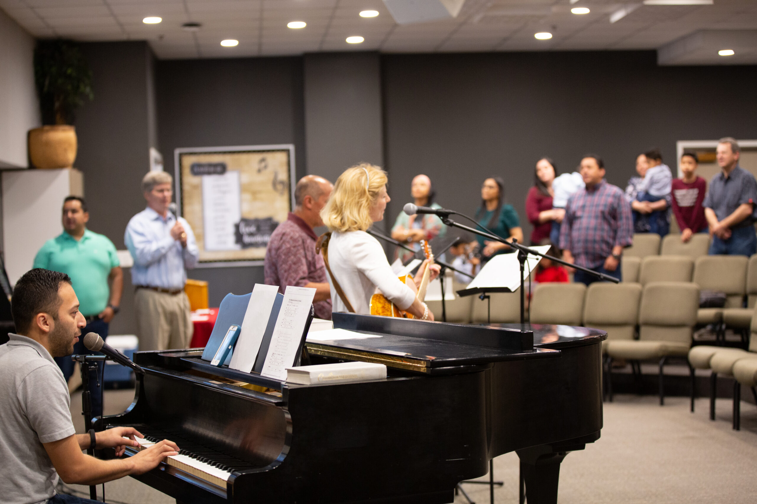 A worship team singing in front of a congregation.