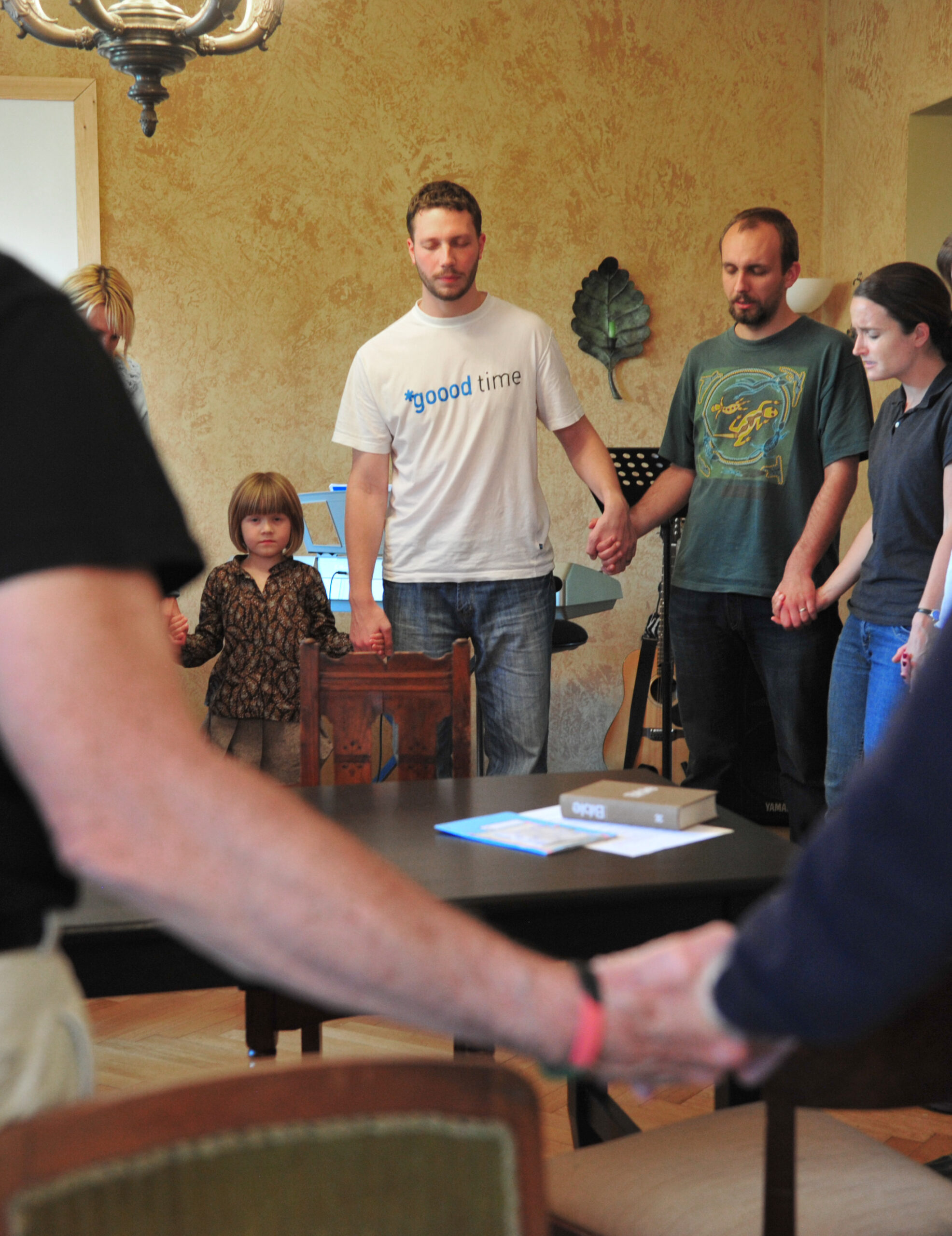 A group standing in a circle holding hands and praying.