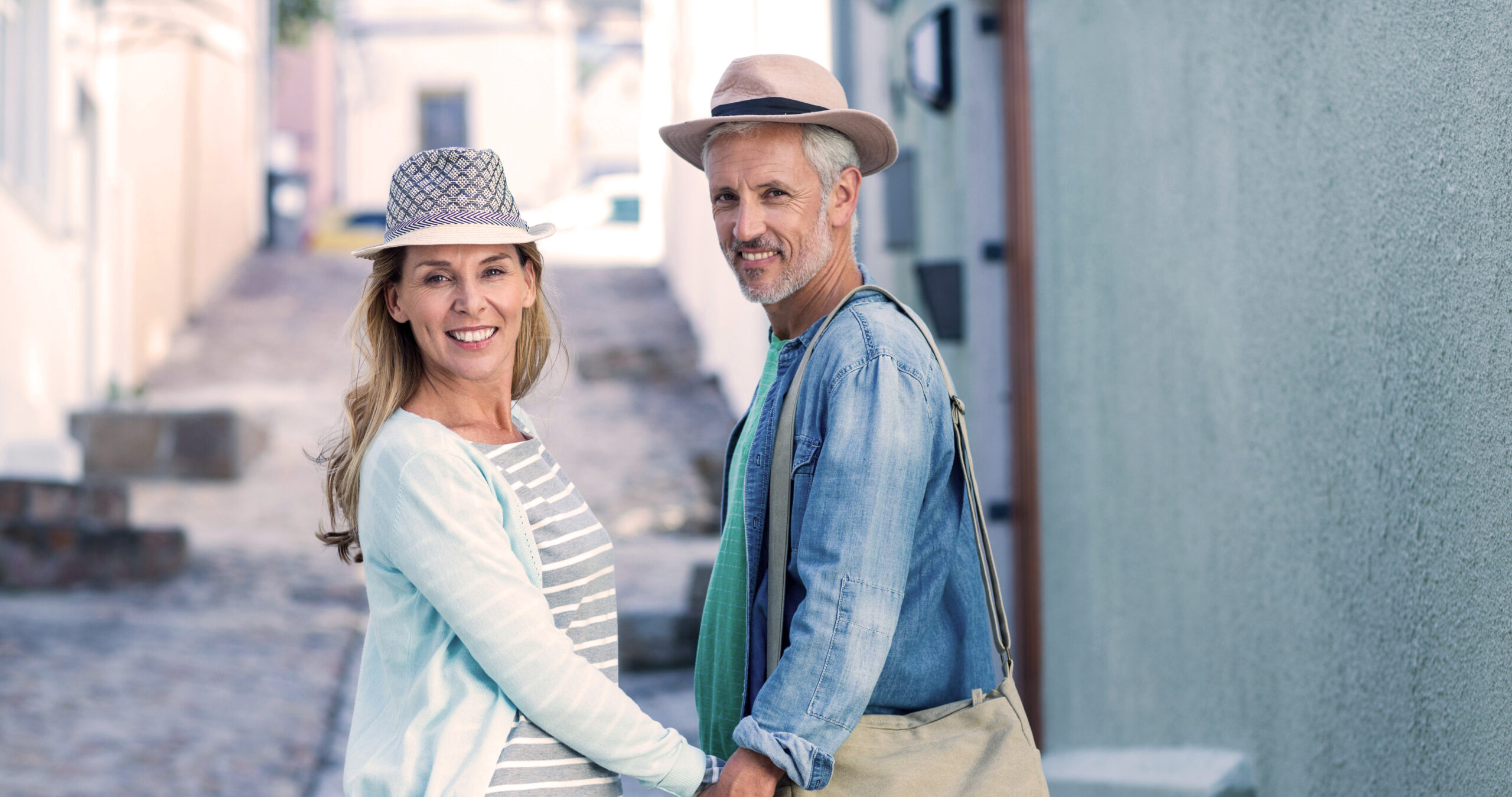 Man and woman holding hands in the street.