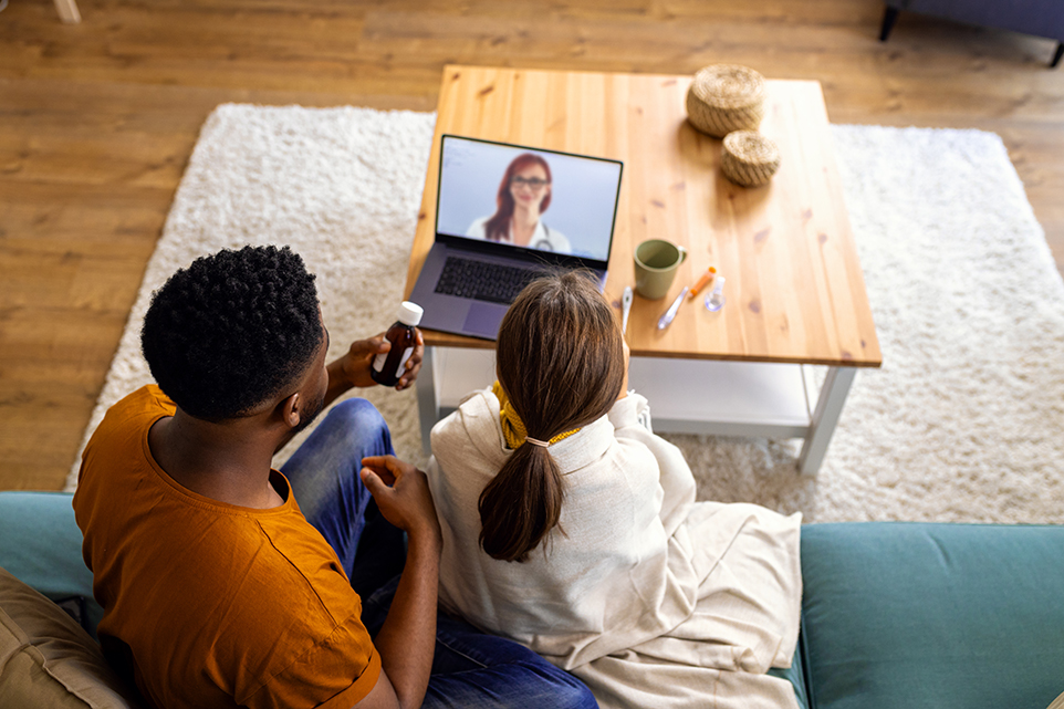 Father and daughter speaking with an online doctor.